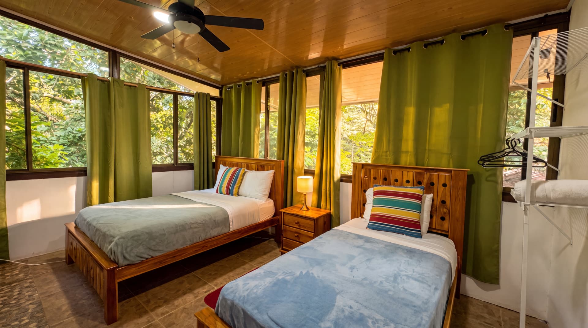 Habitación con dos camas y ventanales hacia el bosque